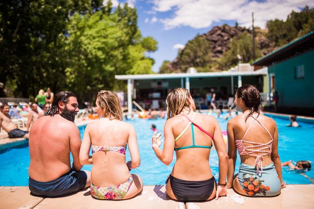 Guests sitting along the edge of the spring-fed pool